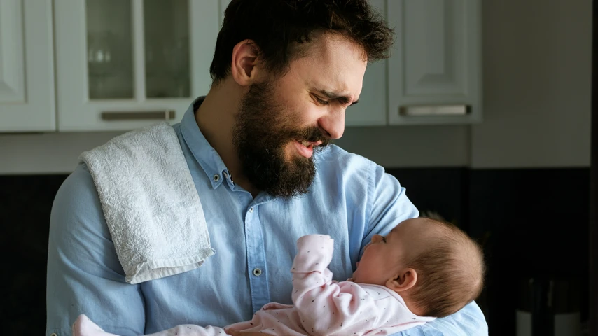 Frustrated father holding baby